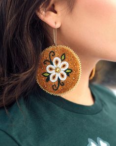 a close up of a person wearing some kind of earring with flowers on it