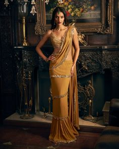 This pre-stitched gold wrap around saree features gold mirror work embroidery. It is paired with fully embroidered matching blouse.From Seema Gujral's Kashish collection DELIVERY TIMEPlease allow 8-12 weeks for your outfit to arrive. FABRIC DETAILSGeorgette Professional cleaning only. Saree Wearing Style, Mirror Work Embroidery, Skirt Set Outfit, Gold Saree, Seema Gujral, Engagement Saree, Mirror Work Saree, Saree Wearing, Sari Dress