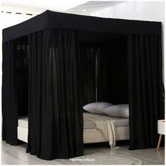 a black canopy bed in a white room