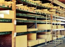 the shelves are filled with many different types of wood planks and boxes on them