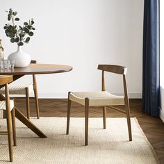 a table with two chairs and a vase on it