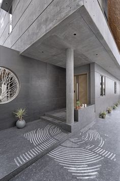 an artisticly designed walkway in front of a concrete building with circular artwork on the floor