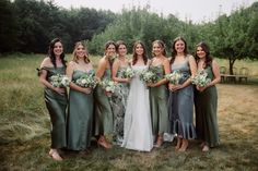 a group of women standing next to each other on top of a grass covered field