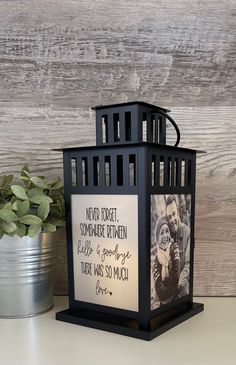 a black lantern with a couple's photo on it and a metal bucket next to it