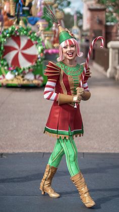 a woman dressed as a nutcracker holding a candy cane