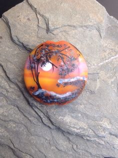 an orange painted rock with a tree on it