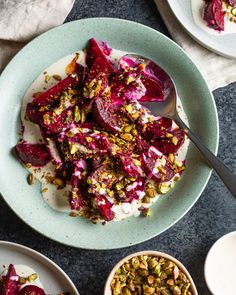 beet salad with yogurt and granola on a blue plate next to other dishes