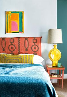 a bedroom with a bed, nightstand and painting on the wall above it's headboard