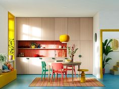 a dining room and kitchen area with colorful furniture