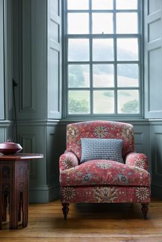 a red chair sitting in front of a window