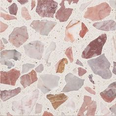 a close up of a marble surface with small pieces of pink and brown rocks on it