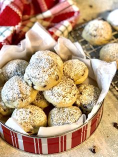 a red and white basket filled with powdered sugar cookies on top of a counter