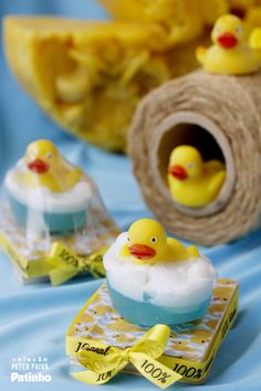 two yellow rubber ducks sitting on top of a blue table cloth next to twine of twine