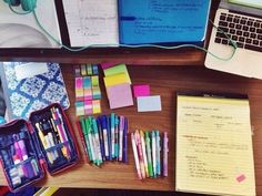 the desk is cluttered with pens, notebooks and other items that are on it