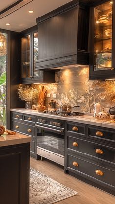 a kitchen with black cabinets and gold accents