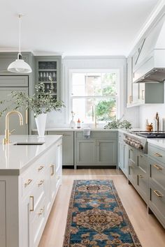 a kitchen with green cabinets, white counter tops and an area rug on the floor