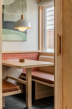 a wooden table sitting in front of a window next to a brown bench and chair