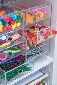 the drawers are filled with plastic toys and other crafting supplies for kids to use