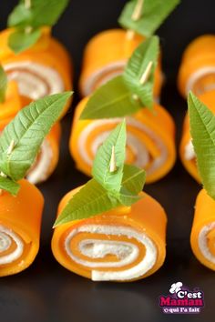 several orange rolls with leaves on top of them