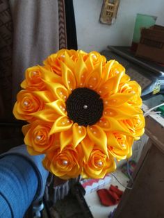 a person holding a yellow flower in their hand