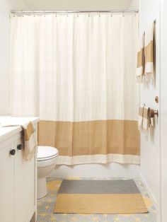 a bathroom with a white toilet sitting next to a shower curtain