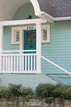 a blue house with a white porch and front door that has the number 2135 on it