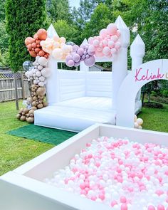 an ice box filled with pink and white balloons