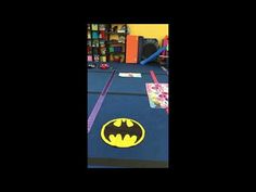 an indoor play area with a batman rug on the floor