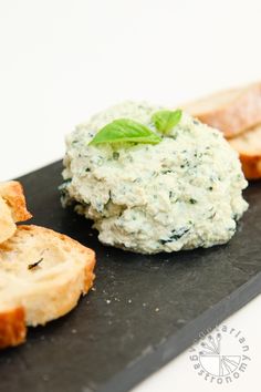 some bread and spinach on a black plate