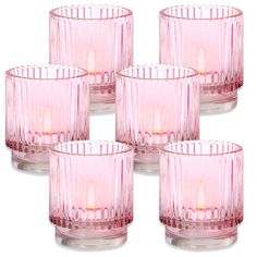 six pink glass candles are lined up in a row