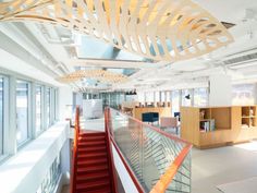 the interior of an office building with red stairs and glass railings on both sides