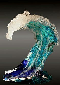 an artistic glass sculpture of a wave in blue and white colors on a black background