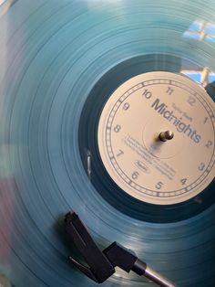 a record player with a clock on it's side next to a pair of scissors