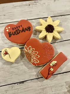 three decorated cookies with happy birthday written on them and sunflowers in the background