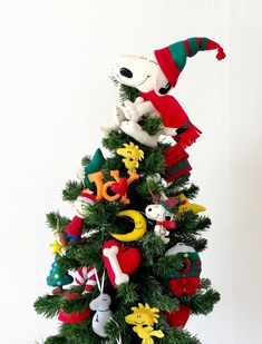 a small christmas tree with ornaments on it and a santa hat hanging from the top