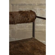 the back of a metal chair with brown fur on it's armrests