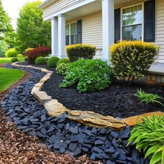 a house with landscaping in front of it and bushes on the side of the house