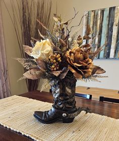 a vase filled with flowers sitting on top of a wooden table next to a rug