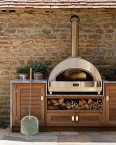 an outdoor pizza oven with wood stacked in it