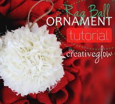 an ornament made out of white flowers on a red cloth with text overlay that reads rag ball ornament