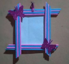 a purple frame with two butterflies on the top and one is cut out to look like an origami butterfly