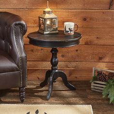 a chair and table with a candle on it in front of a wood paneled wall