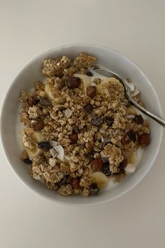 a white bowl filled with granola and nuts