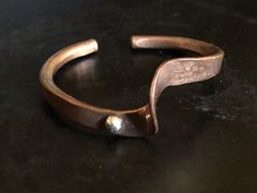 "This interesting bracelet was made from copper with a shiny ball detail in sterling silver. Half of the bracelet has a hammered surface, the other half which includes the ball is mirror smooth. Nice, thoughtful, modern piece. The interior is stamped sterling and JC. The bracelet fits a 6 3/4\" wrist just right. It is 6cm (2 3/8\") wide X 4cm (1 9/16\"). The opening is 3cm (1 3/16\"). There is some give to it." Puka Shell Necklace, Copper Cuff Bracelet, Puka Shell, Copper Cuff, The Other Half, Butterfly Bracelet, Other Half, Hammered Copper, Shell Necklaces