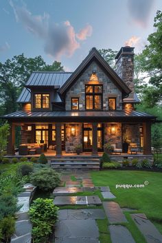 a large stone house with lots of windows and lights on it's front porch