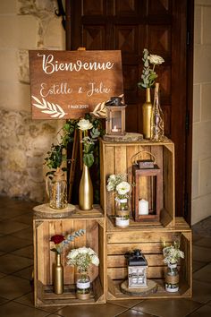 a wooden crate with flowers and candles on it sitting in front of a sign that reads bierene ete de jolie