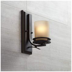 a light fixture mounted on the side of a wall next to a white tiled wall