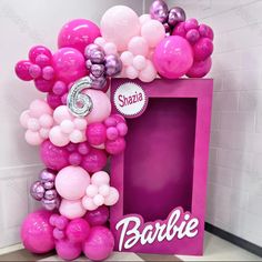 the balloon arch is decorated with pink, purple and silver balloons that spell out barbie