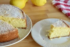 two plates with slices of cake on them next to some lemons and a towel