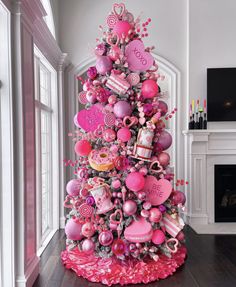 a pink christmas tree decorated with hearts and candies